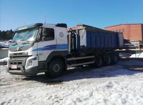 Kuorma-auto pysäköitynä lumisella pihalla