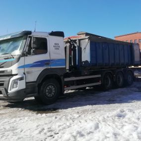 Kuorma-auto pysäköitynä lumisella pihalla